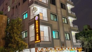 A multi-story hotel with a prominent sign reading "MANTRA INN" and "STAY WITH JOY". - Mantra Inn (Pune)