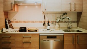 Une cuisine moderne avec des meubles en bois, un lave-vaisselle en acier inoxydable et un dosseret carrelé.