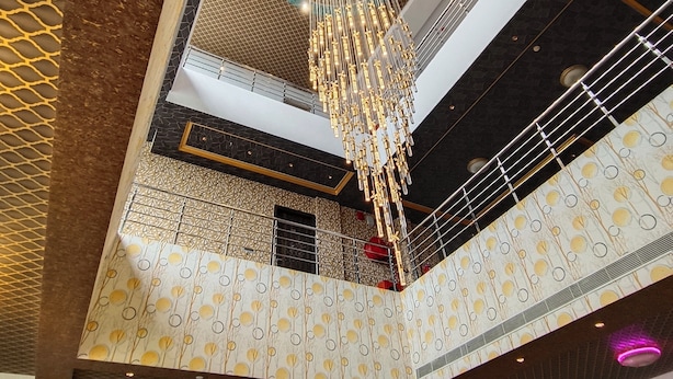 A multi-level atrium with a central chandelier, patterned walls, and a staircase. -  Bellazio Suites Hotel and Resort Bellazio (Bareilly)