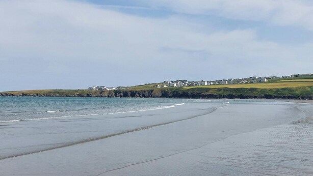 A beach with a clear view of the sea and a distant town. - Y Cartws, Cardigan - Two Bedroom Cottage, Sleeps 4 (Cardigan)