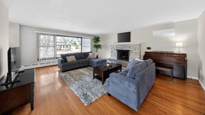 Ein Wohnzimmer mit Kamin, einer Couch, einem Couchtisch und einem Fernseher.