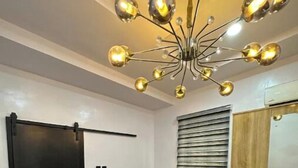 A modern bedroom with a bed, a wardrobe, and a unique chandelier. - Classic 2bedroom Flat in GRA

 (Ikeja)