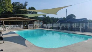 Une piscine dotée d’un espace ombragé, de chaises longues et d’un coin salon abrité.