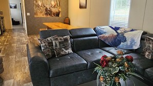 A living room with a sofa, coffee table, and a ceiling fan. - Classy 3 Bed home w/ pool access - Moose Cabin (Elizabeth)