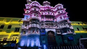 A multi-story building with ornate architectural details and illuminated windows. - INDORE INTERNATIONAL CONVENTION CENTER (Sanwer)