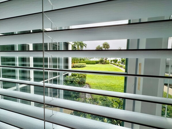 A modern building with large windows and a view of a well-maintained lawn and trees.