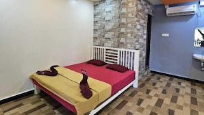 Un dormitorio con cama, pared de acento de piedra, baño con lavamanos y techo con diseño circular.