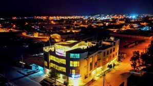 A modern building with multiple floors, large windows, and a flat roof. - Sechura Hotel Casa Blanca Piscina Garaje (Sechura)