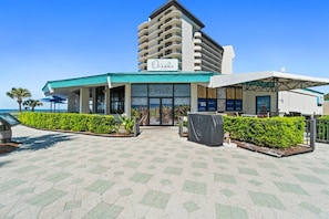 A hotel with a sign reading 'Oceans' and a covered outdoor area with seating.