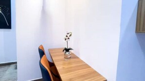 Een kleine, moderne eetruimte met een houten tafel en twee stoelen.