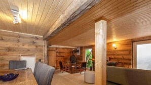 A rustic wooden interior with a dining area, seating, and a fireplace. - Chalet in Rossiniere With Sauna and Mountain Views (Chateau-d'Oex)