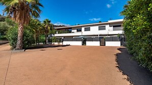 A modern building with a flat roof, large windows, and a covered entrance.