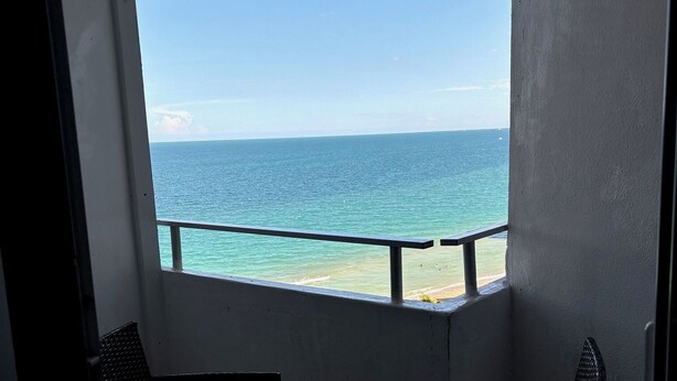 A balcony with a view of the sea, a railing, and two wicker chairs. - Ocean view with balcony private  Efficieny  atThe OceanManor (Fort Lauderdale)