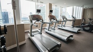 A gym with treadmills and exercise equipment, large windows with a city view, and a modern interior design. - Centrally Located 1-BR Condo in DT Toronto (Toronto)