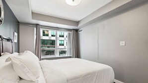 Ein Schlafzimmer mit einem Bett, einem Fenster und einer Deckenleuchte.