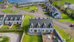 A residential area with houses, a road, and a lake in the background. - 2 Bedroom Home in Kenmare With sea Views to Sleep 4 (Kenmare)
