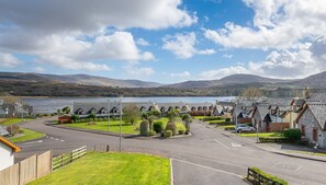 A coastal village with stone houses, a road leading to a beach, and a view of the sea and hills in the distance. - 2 Bedroom Home in Kenmare With sea Views to Sleep 4 (Kenmare)
