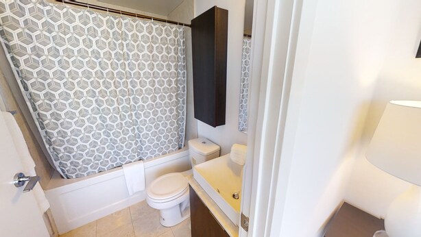 Une salle de bain avec douche, toilettes et lavabo.