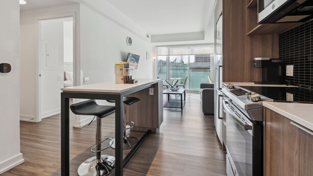 A modern kitchen with a central island, stainless steel appliances, and a view to the outside. - Lovely 1-BR in DT Toronto (Toronto)