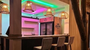 A bar area with wicker chairs and a Corona sign. - Hotel All In One  (Armenia)