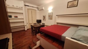 Une chambre à coucher avec un lit, un bureau, une chaise et un téléviseur.