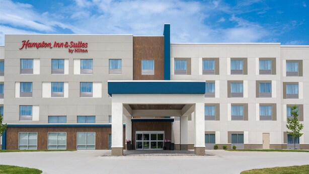 A modern hotel with a prominent sign, a central entrance, and a symmetrical facade.