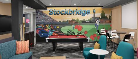A pool table in a lounge area with teal chairs and a billiards table.