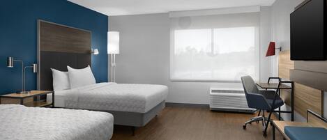 A hotel room with two beds, a desk, a chair, a TV, and a window with a city view.