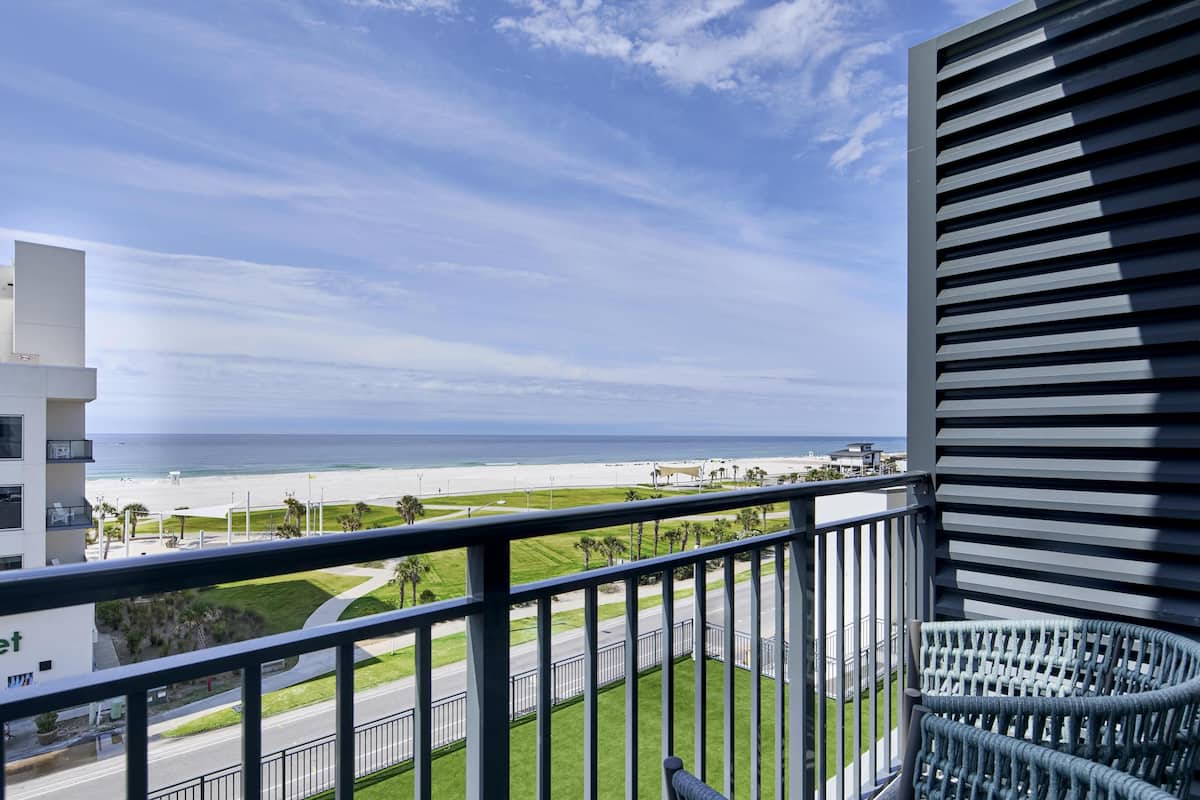 Ein Balkon mit Blick auf Strand und Meer.
