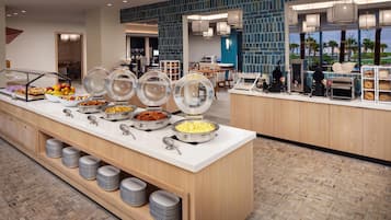 Buffet-alue, jossa on tarjolla monenlaista ruokaa, sekä kahviautomaatti.