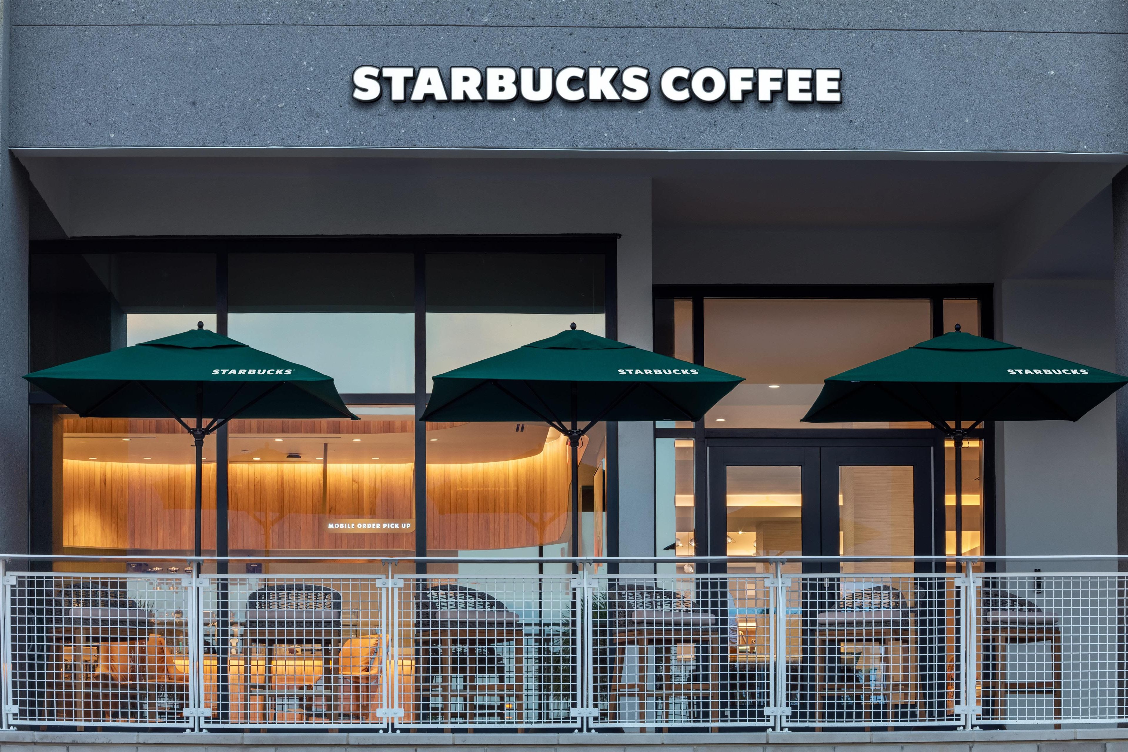 Un établissement Starbucks proposant du café, avec des places assises en extérieur et un service de retrait des commandes passées en ligne ou via une application mobile.