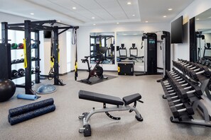 A gym with various exercise equipment, including a treadmill, weight bench, and free weights. - Home2 Suites By Hilton Memphis Downtown (Memphis)