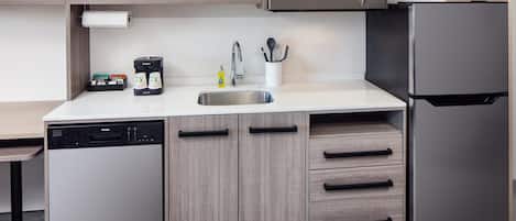 Cozinha moderna equipada com lava-louças, cafeteira, micro-ondas e frigorífico.