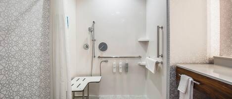 A modern bathroom with a shower, a toilet, and a sink.
