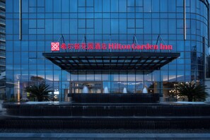 A modern building with a large glass facade and a prominent sign for Hilton Garden Inn. - Hilton Garden Inn Shanwei Haibin Boulevard (Shanwei)