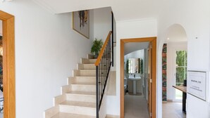 Un escalier menant à une salle de bain équipée d’un lavabo et d’un miroir.