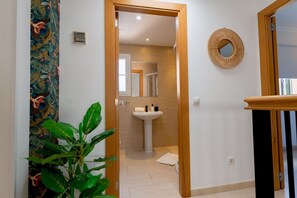 Ein Badezimmer mit Waschbecken, Spiegel und Holztür.