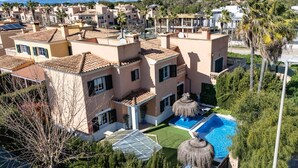 Un quartier résidentiel comprenant plusieurs maisons, une piscine et offrant une vue sur les montagnes lointaines.