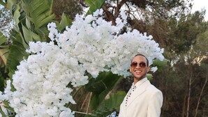 Une personne se tient devant un grand arrangement floral blanc.