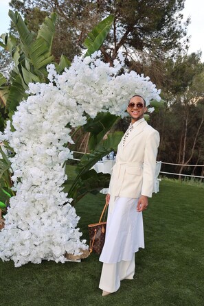 A person standing in front of a large white floral arrangement.