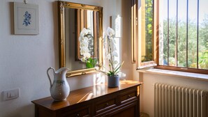 A wooden dresser with a vase and a mirror.