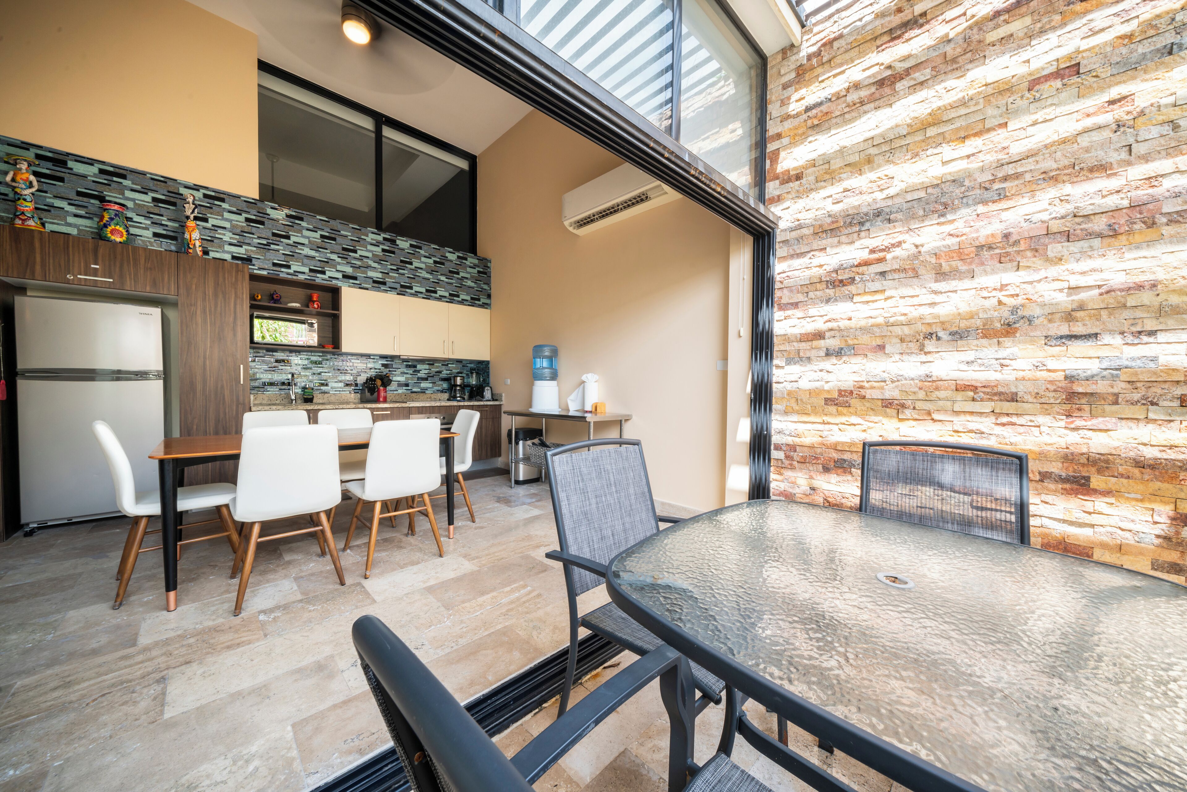 Una cocina moderna con comedor, que incluye una mesa grande, sillas y una isla de cocina.