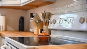 Een keuken met een fornuis, een muffin op het fornuis en een messenblok op de achtergrond.