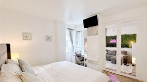 A modern bedroom with a large bed, a desk, and a TV. - Pool & Jacuzzi! Walk to beach, South Point Pier, (Miami Beach)