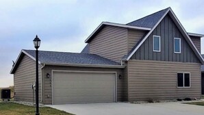 Ein zweistöckiges Haus mit Garage, Auffahrt und einer Straßenlaterne.