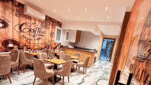 A modern dining area with marble flooring, wooden accents, and a central island. - Olivia Hotel (Cairo)