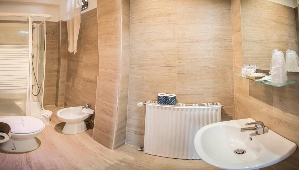 A modern bathroom with a toilet, bidet, and sink.