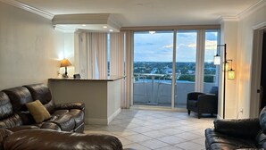 A spacious living room with two leather sofas, a small table, and a view of the city through large windows. - Tortuga festival special 1Bedroom  Suite,CityView Ft Lauderdale&Two QueenBeds (Fort Lauderdale)