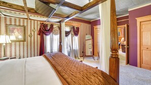 Un letto a baldacchino con una testiera in legno, uno specchio grande e un quadro appeso al muro.