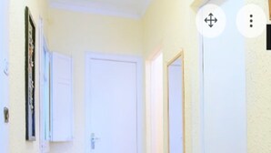 A narrow hallway with a tiled floor, white walls, and a closed door at the end. - Private room (1) near the University with large terrace of 150 m2.  (Barcelona)